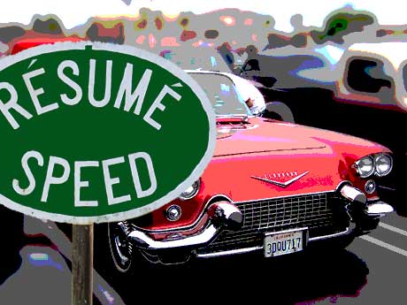 a resume speed sign with a classic cadillac behind it